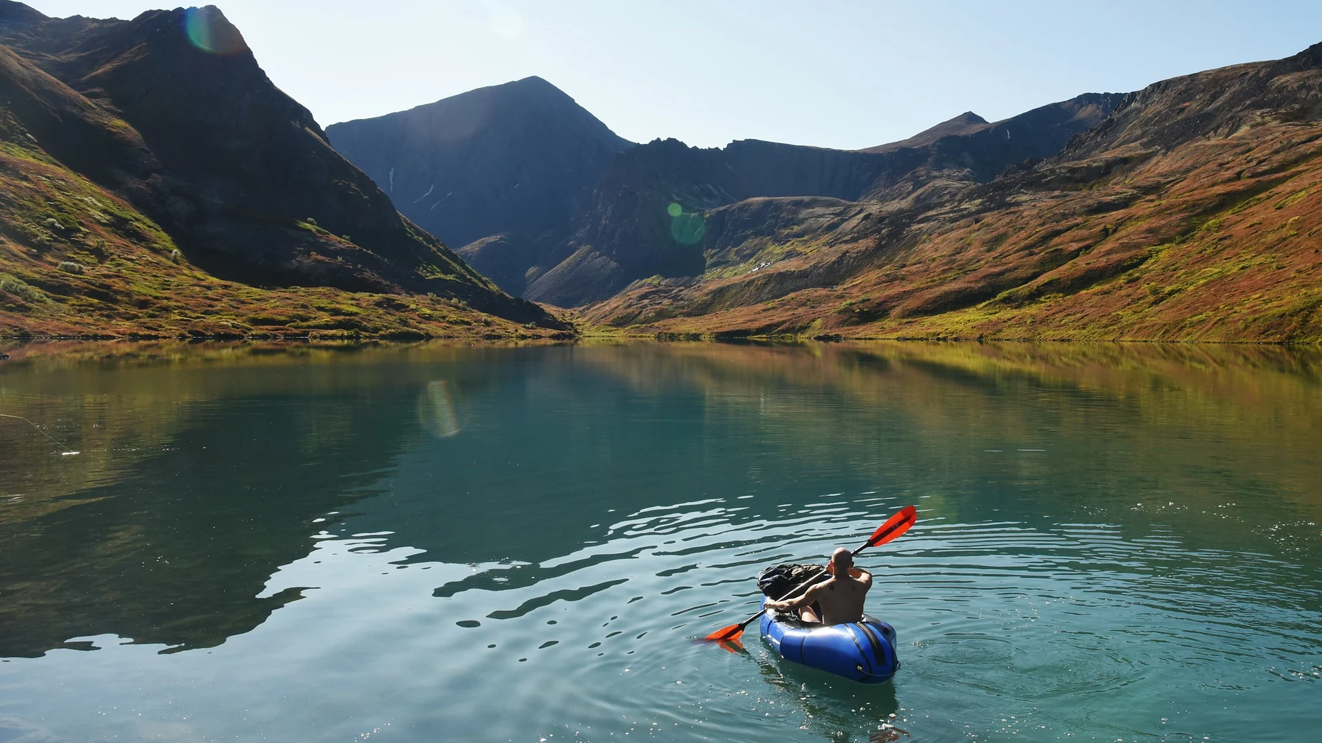 Paddler auf dem klaren Symphony Lake zwischen kargen Bergen im Chugach State Park