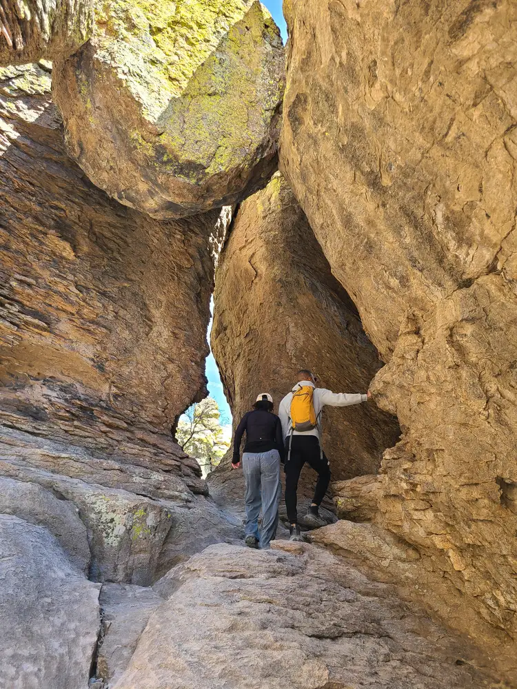Zwei Wanderer in einem schmalen Durchgang zwischen hohen Felswänden in Chiricahua
