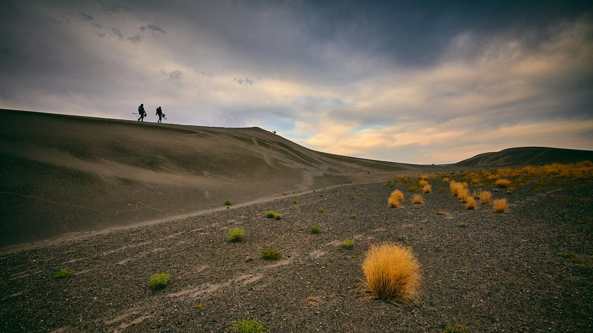 Zwei Wandernde stehen auf dem Kamm einer Düne im Bruneau Dunes State Park
