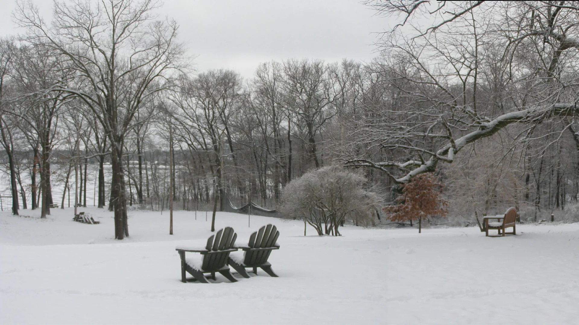 Leere Adirondack-Stühle stehen im verschneiten Pokagon State Park