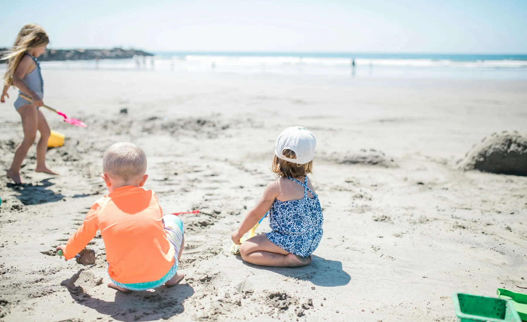 Drei Kinder spielen an einem sonnigen Strand in Oceanside in Kalifornien