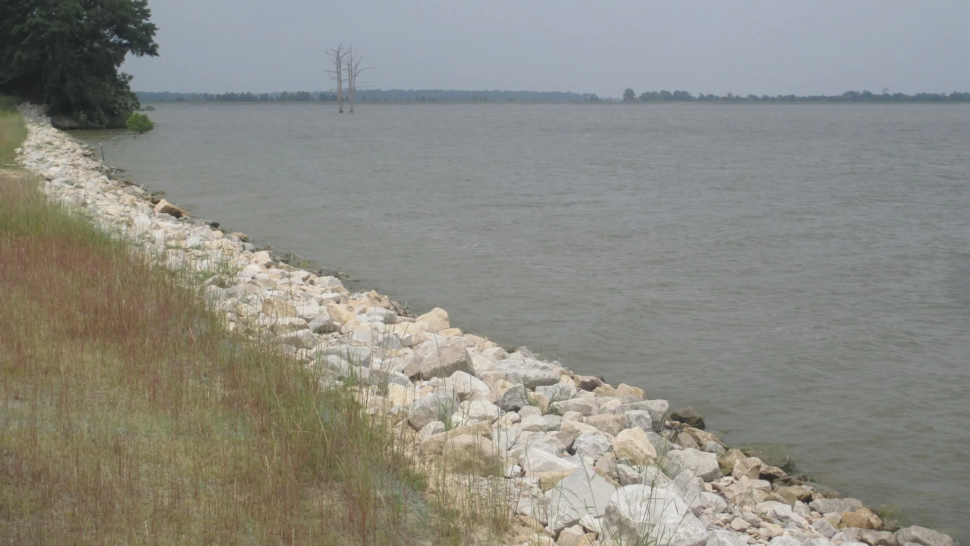 Steinbefestigtes Ufer am weiten Poverty Point Reservoir