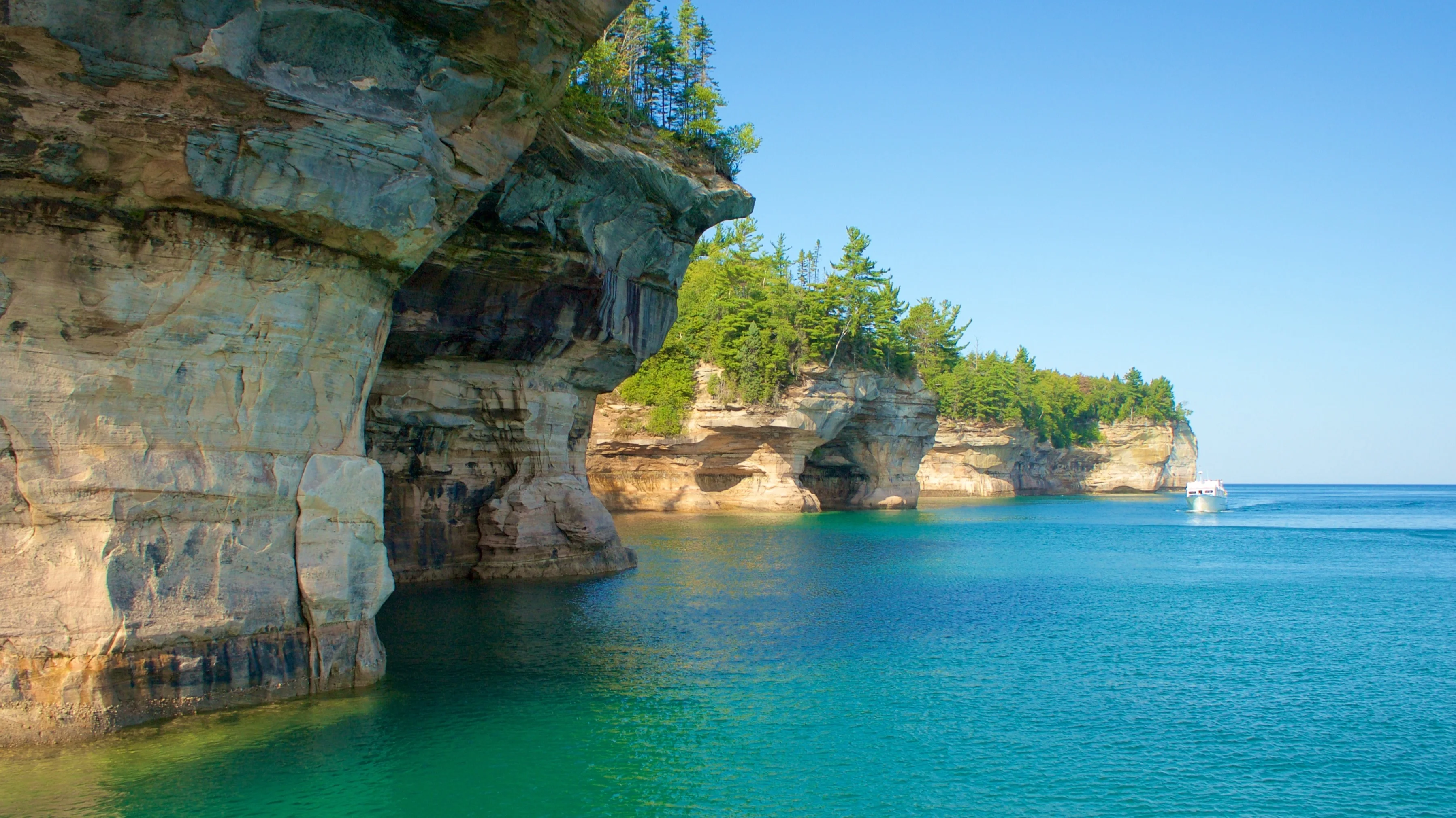 Mineralgefärbte Sandsteinfelsen an türkisblauem Wasser in der Pictured Rocks National Lakeshore