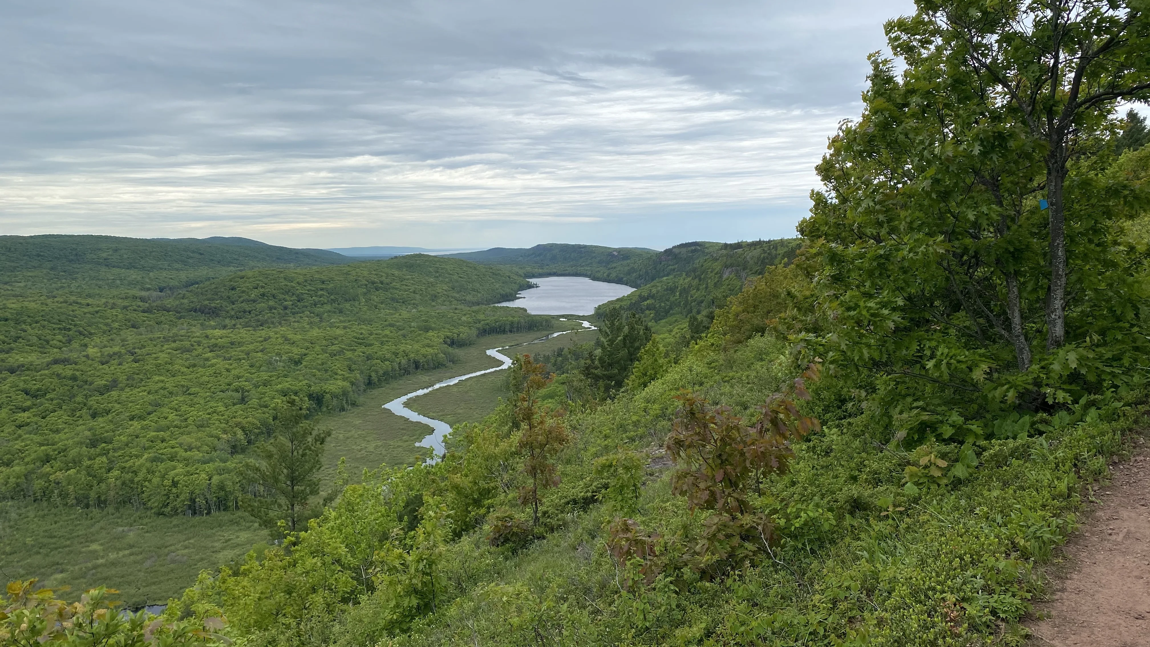 Lake of the Clouds und der gewundene Carp River zwischen bewaldeten Hügeln der Porcupine Mountains