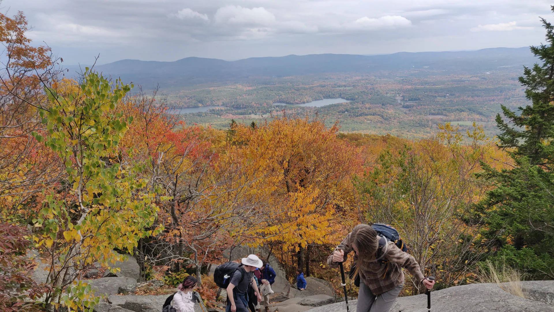 Wandernde steigen im Herbst über Granitplatten am Mount Monadnock auf