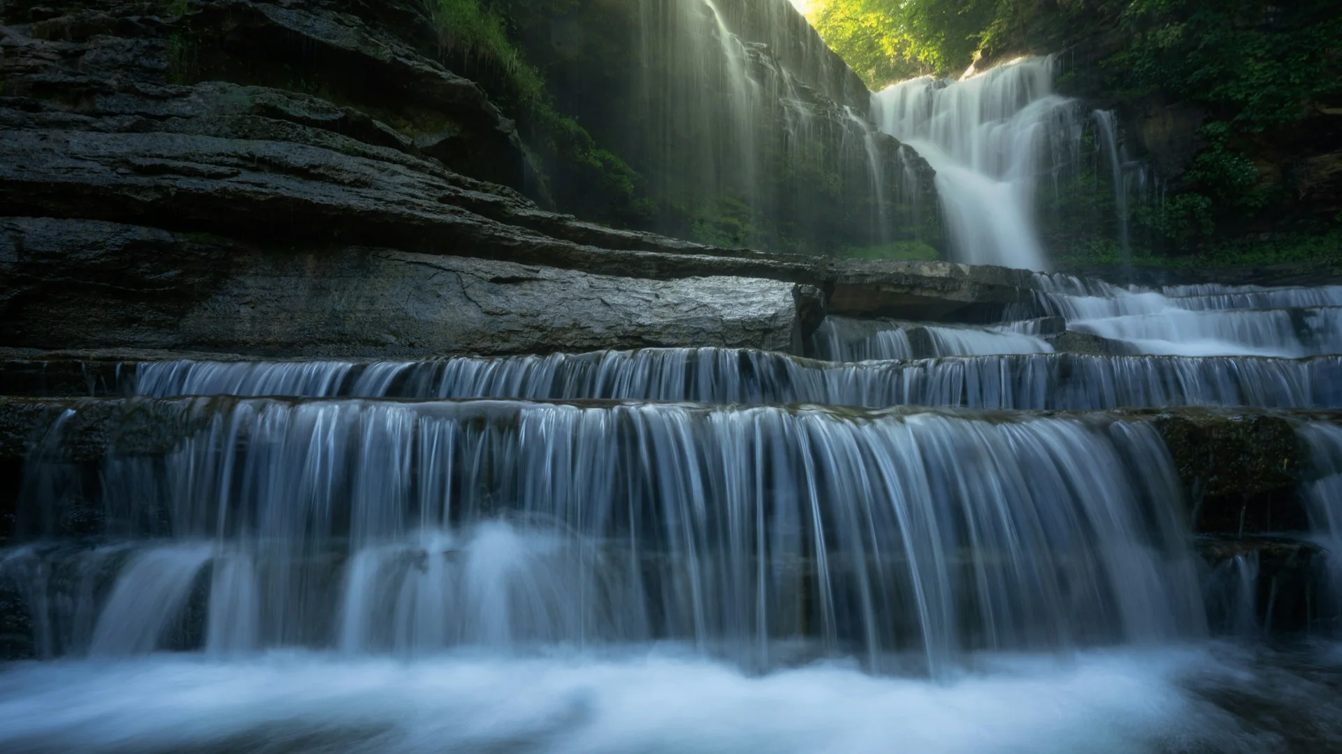 Mehrstufiger Wasserfall über dunklen Felsstufen im Cummins Falls State Park
