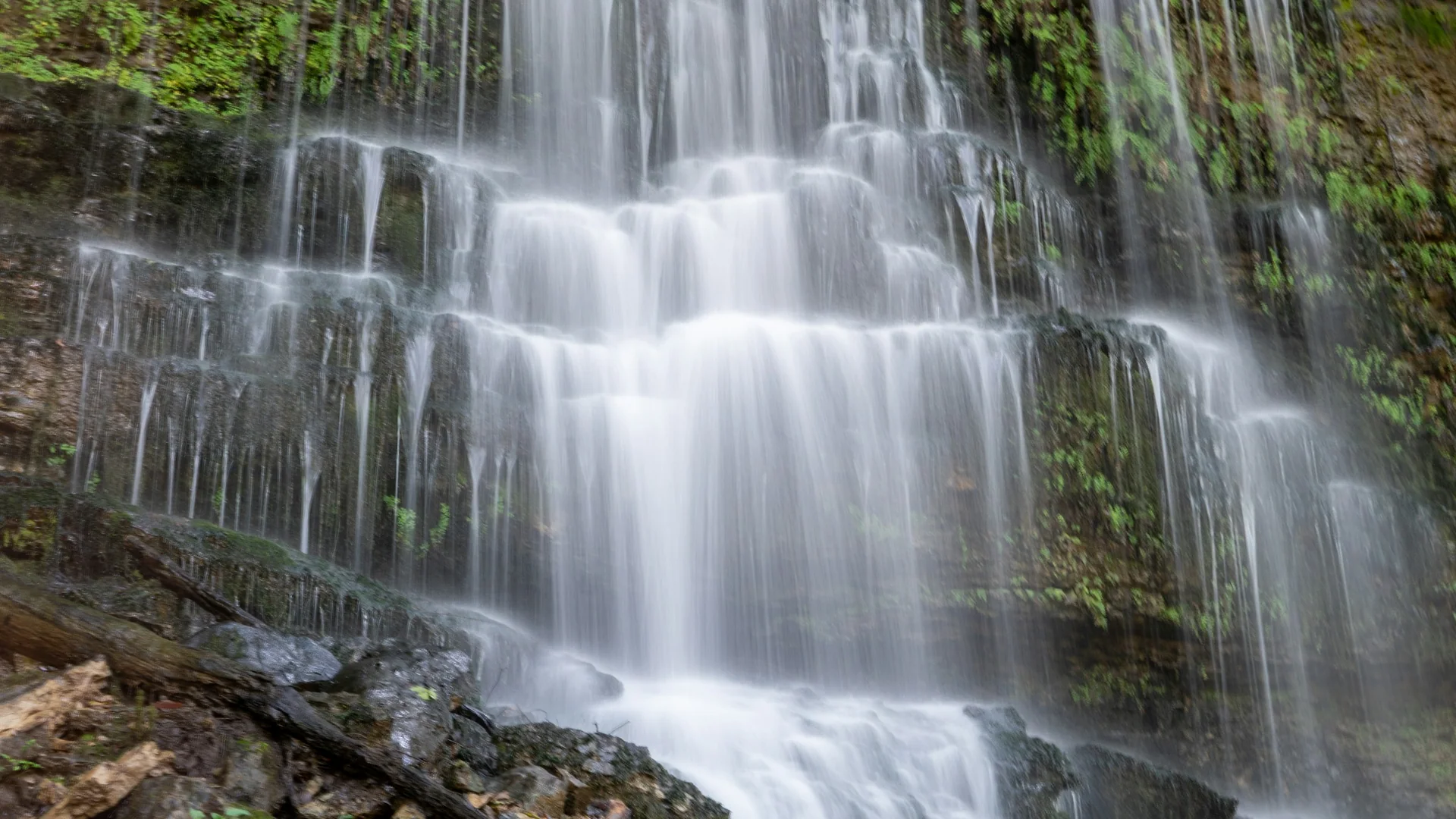 Breiter Schleierwasserfall über moosigen Felsen im Rock Island State Park in Tennessee