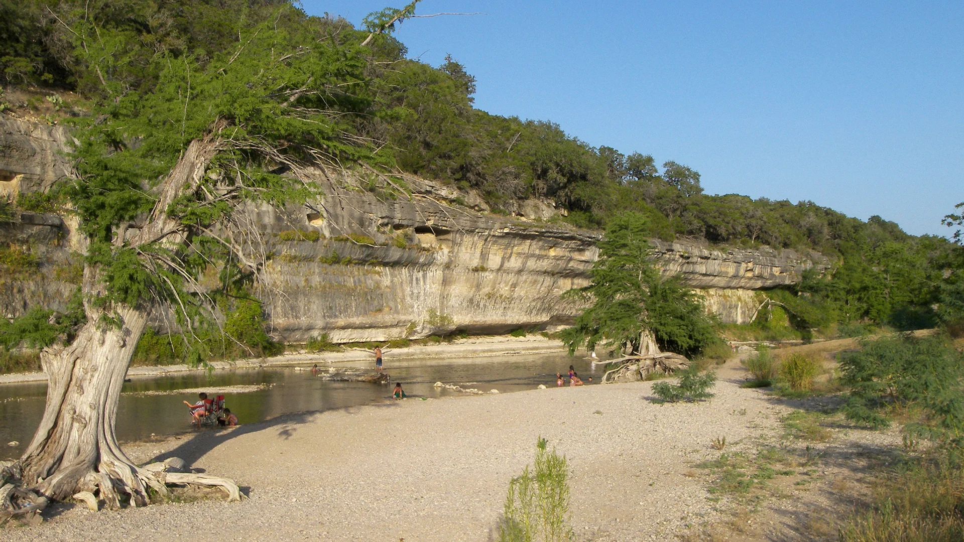 Helle Kalksteinwand, Zypressen und Flussufer im Guadalupe River State Park