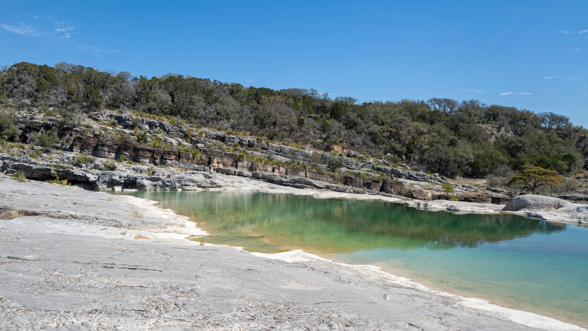 Türkisfarbenes Wasser zwischen breiten Kalkstufen im Pedernales Falls State Park