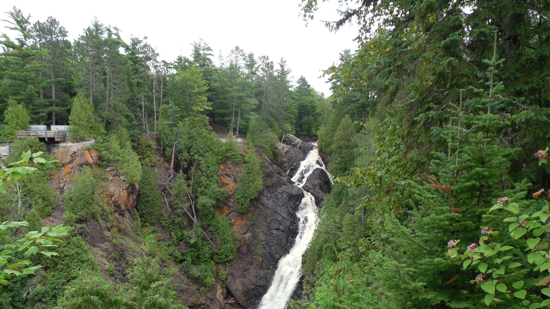 Big Manitou Falls fällt zwischen dunklen Felsen und dichtem Wald in die Tiefe