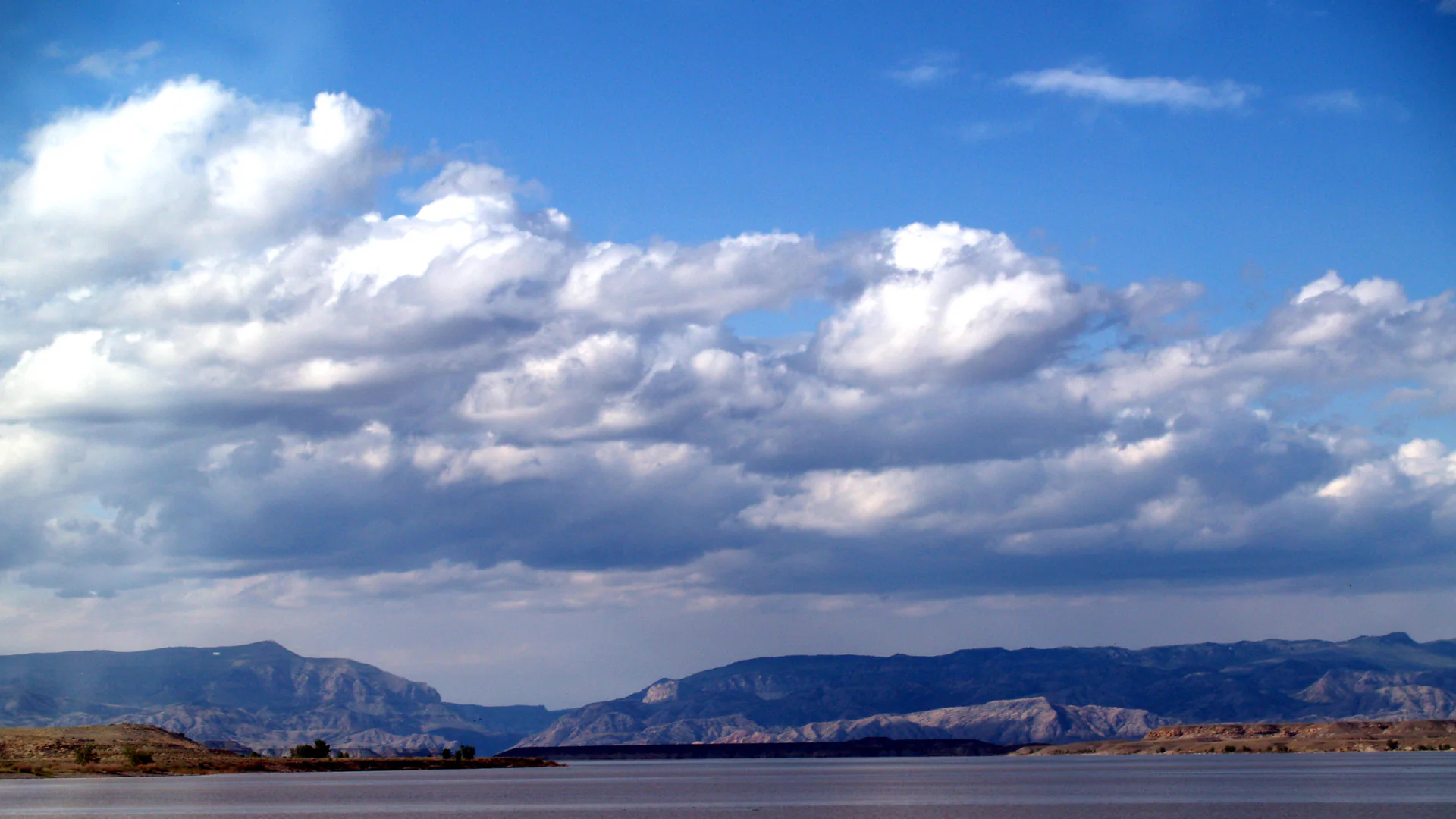 Boysen Reservoir vor kargen Bergketten und einem weiten Wolkenhimmel in Wyoming