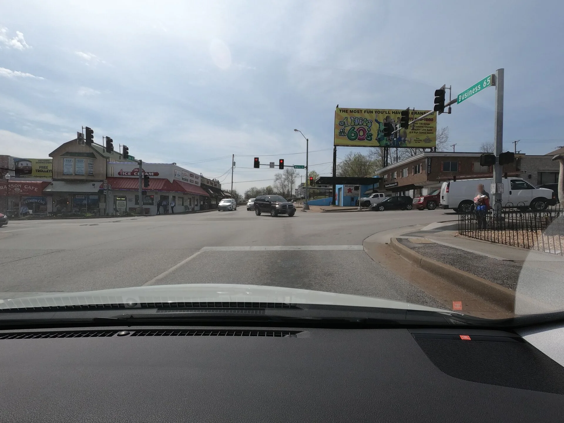 The intersection of Veterans Boulevard at West Main Street looking southbound in Branson, Missouri, United States. Business U.S. Route 65 and Missouri Route 76 are both ahead and to the right.
The pedestrian crosswalks at this intersections are unmarked even though they are controlled by pedestrian traffic signals. This configuration conforms to the MUTCD and the Missouri Department of Transportation’s Engineering Policy Guide. It is common in some regions but not others.