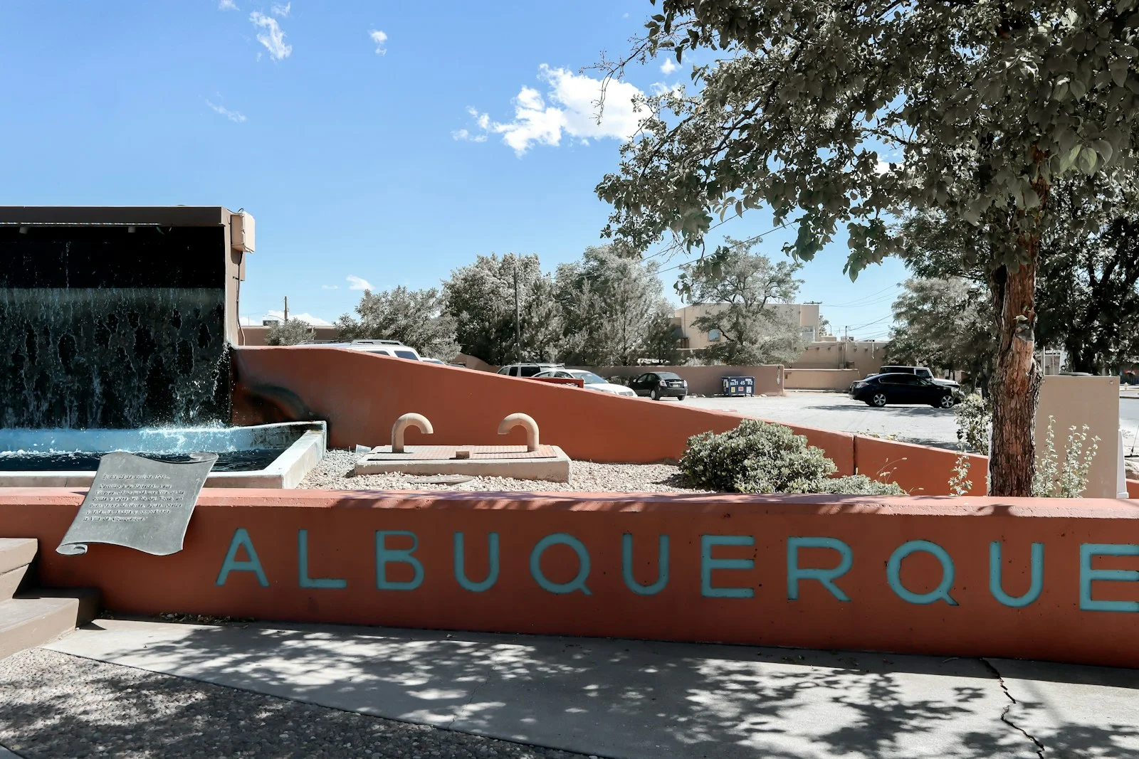 a sign that reads albuqueroque with a waterfall in the background
