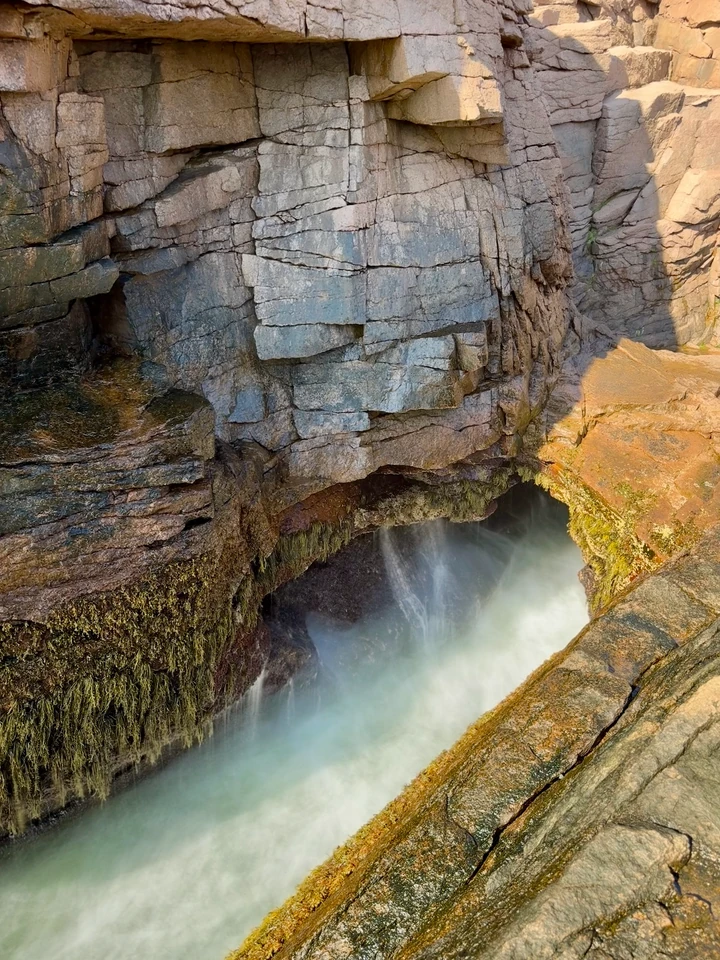 Weißes Meerwasser schäumt in der schmalen Felsöffnung von Thunder Hole