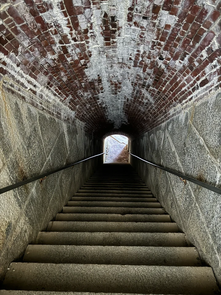 Steile Treppe zwischen den gemauerten Wänden eines schmalen Gangs in Fort Knox