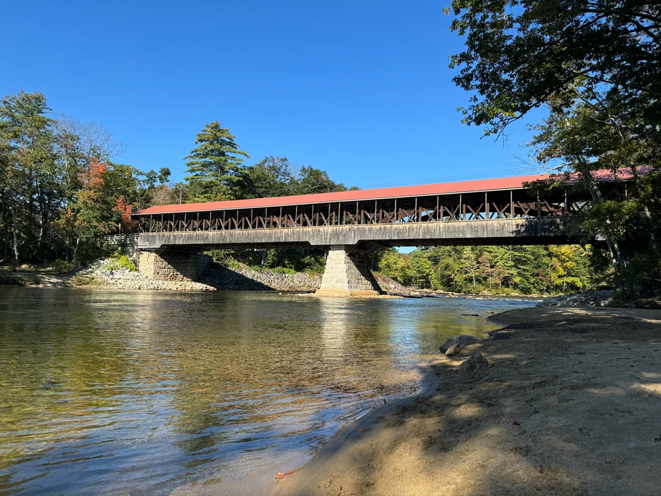 Historische überdachte Holzbrücke in Conway vom Flussufer aus
