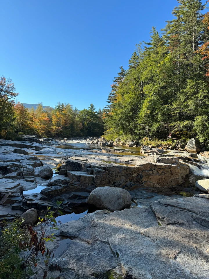 Swift River über Granitflächen zwischen herbstlich gefärbten Bäumen bei Rocky Gorge
