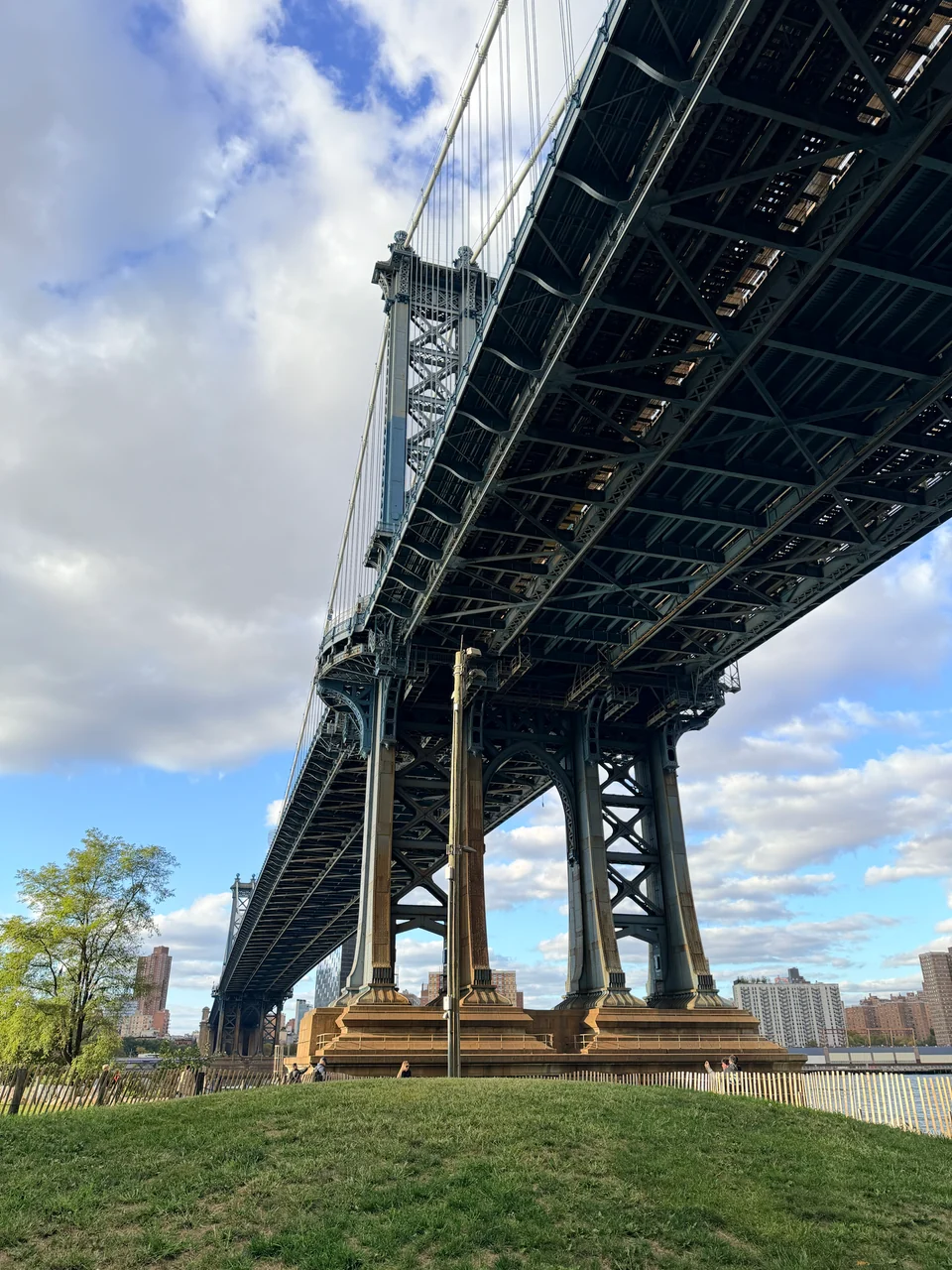 Stahlträger der Manhattan Bridge über dem Uferbereich in DUMBO