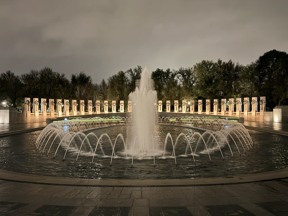 Brunnenbecken und beleuchtete Pfeiler des World War II Memorial bei Nacht