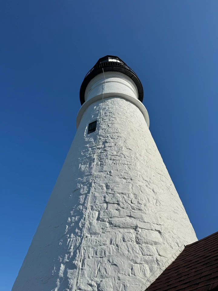 Weißes Mauerwerk des Portland Head Light aus der Nähe mit dunkler Laterne