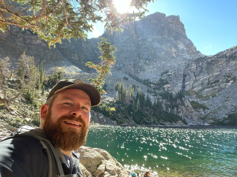 Tobias am Emerald Lake vor Wasser und steilen Bergwänden