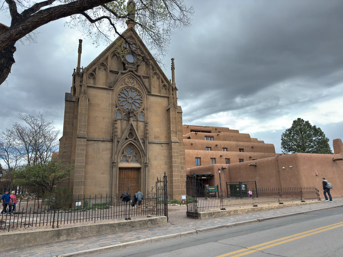 Neugotische Fassade der Loretto Chapel neben Adobe-Gebäuden am Old Santa Fe Trail