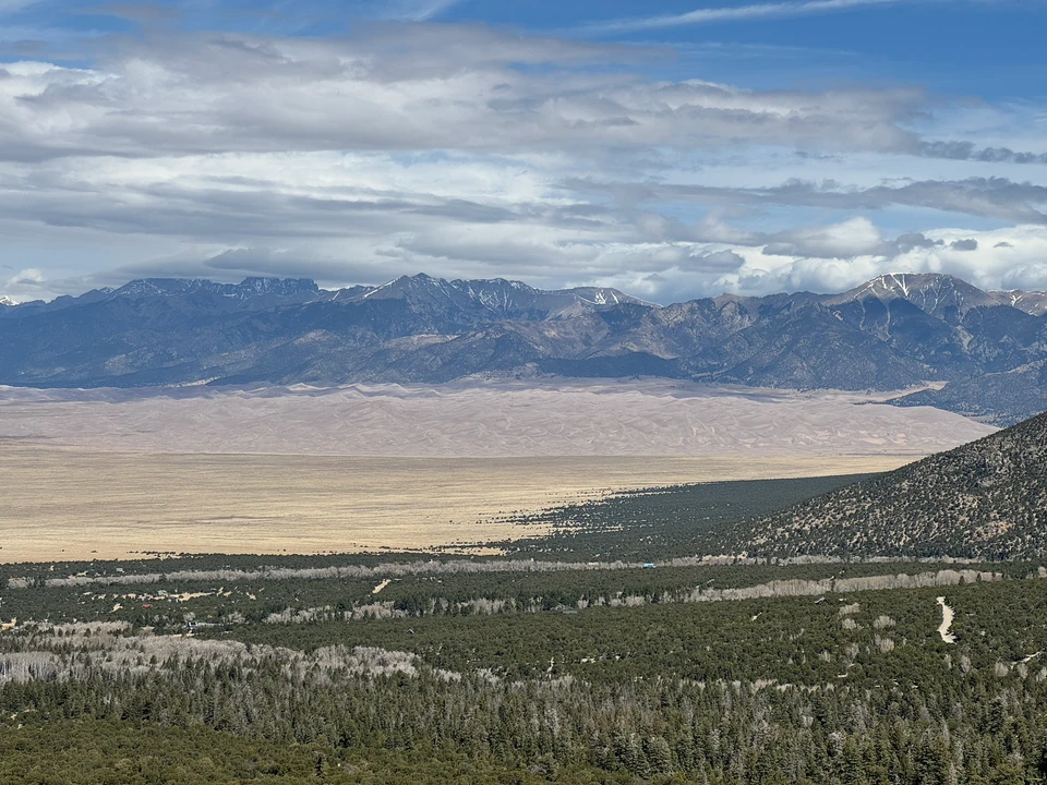 Blick über das San Luis Valley zu den hellen Great Sand Dunes und den Bergen