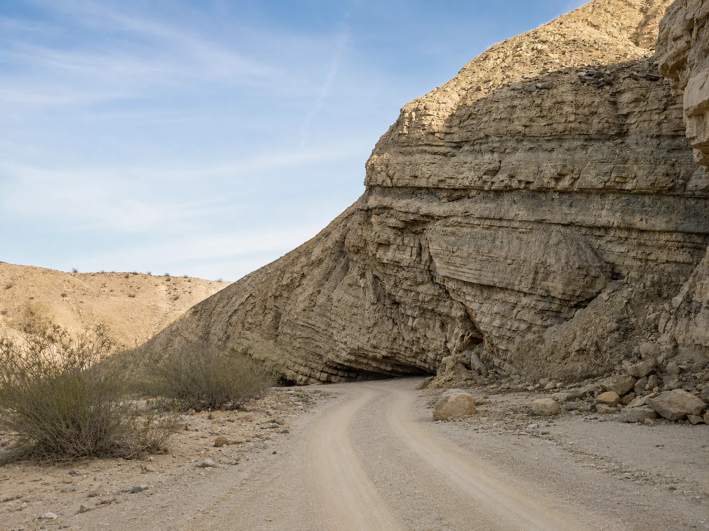 Sandige Piste entlang einer markanten Felswand in Anza-Borrego